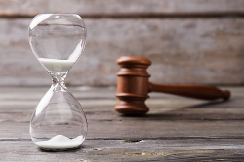 Hourglass and judge gavel representing car accident statute of limitations in Georgia
