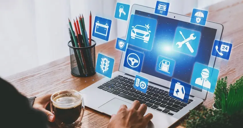 A person holds a coffee cup while browsing a laptop that projects floating blue icons related to auto insurance-repairs-and roadside assistance representing the online research accident victims often conduct to understand their rights before responding to a first settlement offer in Metro Atlanta.